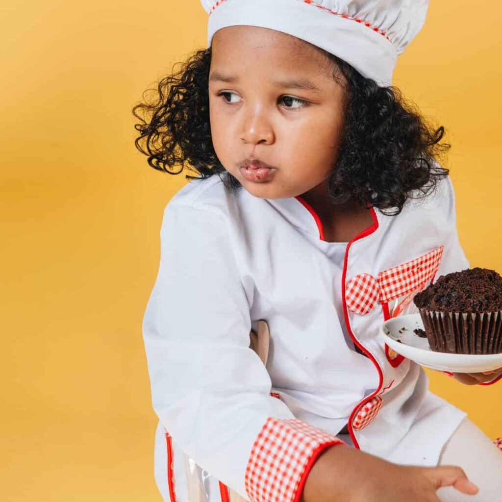 cute black girl chewing sweet baked dessert